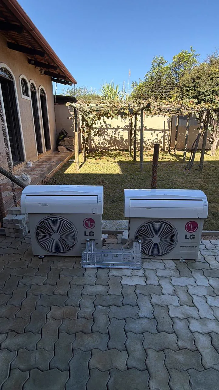 Duas condensadoras LG lado a lado no piso de um quintal.
